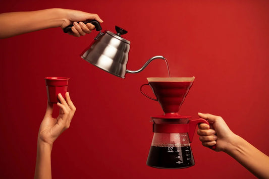 Pouring water from a gooseneck kettle over a V60 dripper to brew pour-over coffee
