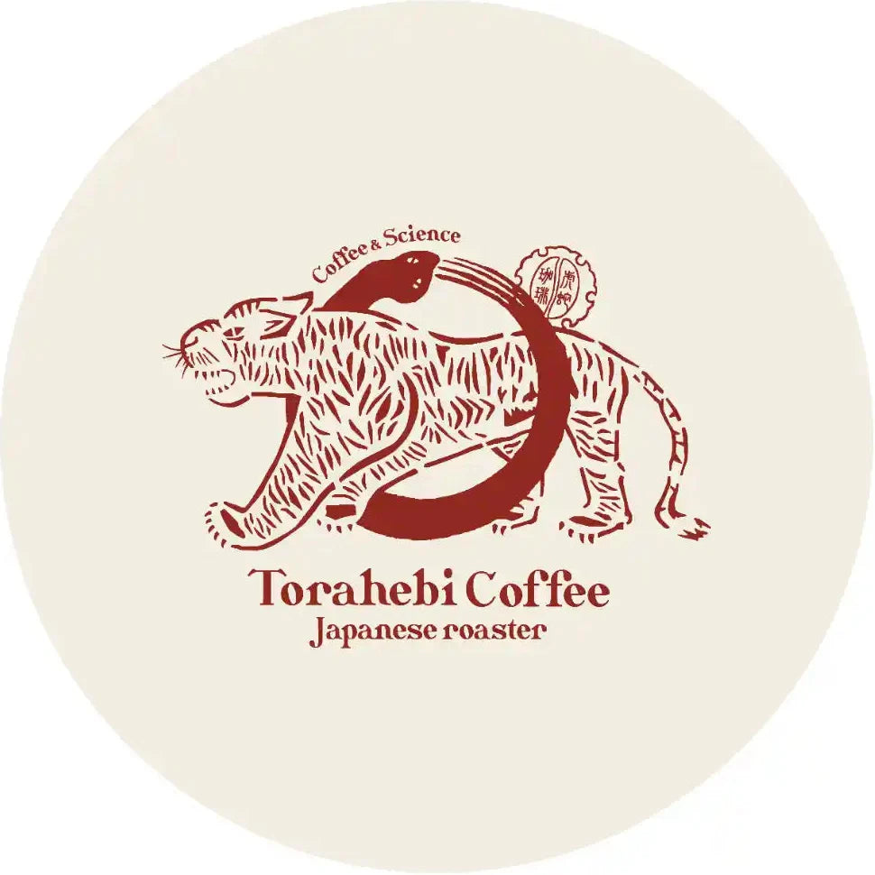 A circular logo graphic featuring a stylized red tiger and cat illustration with the text 'Coffee Science' and 'Torahebi Coffee Japanese roaster' on a cream background.