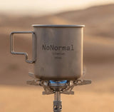 NoNormal Titanium Cup 380ml in silver titanium finish with foldable handles for camping and outdoor use