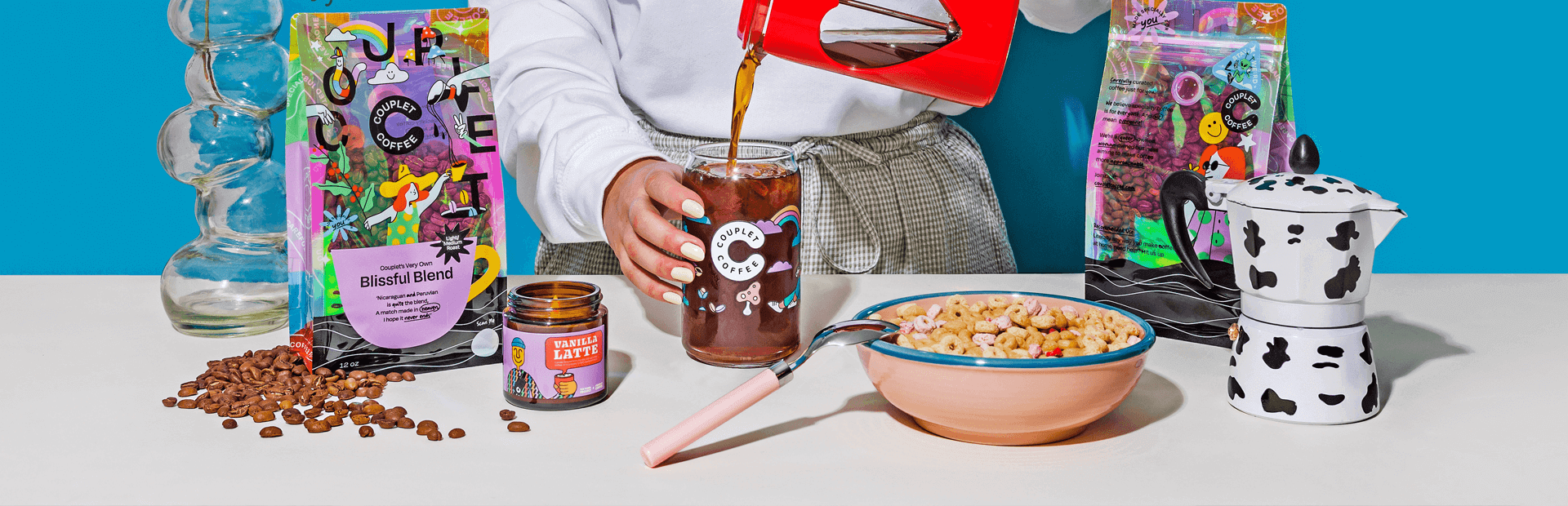 A person pouring coffee into a glass with coffee beans and breakfast items, showcasing Dubai's vibrant drinkware and accessories.