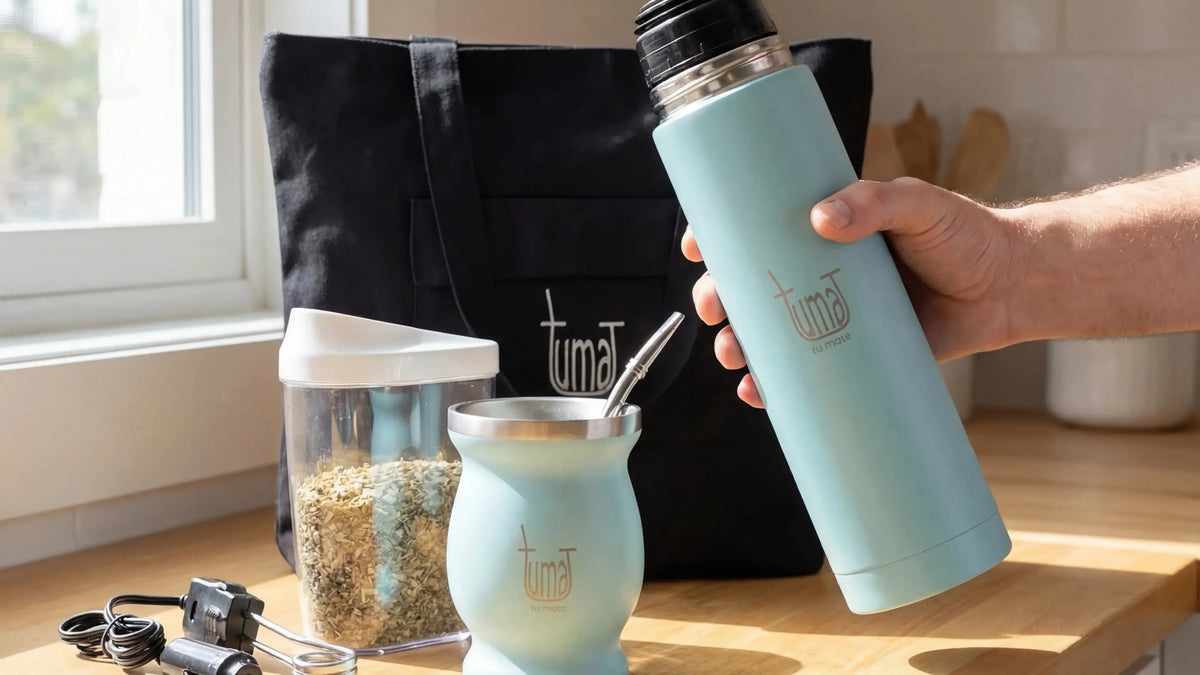 Person holding a teal thermos bottle on a kitchen counter with a Tumat brand logo.