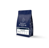 The Coffee Lab Brazil coffee beans in premium dark blue packaging, featuring Brazilian specialty coffee with chocolate, nut, and caramel flavor notes and a natural processing method.