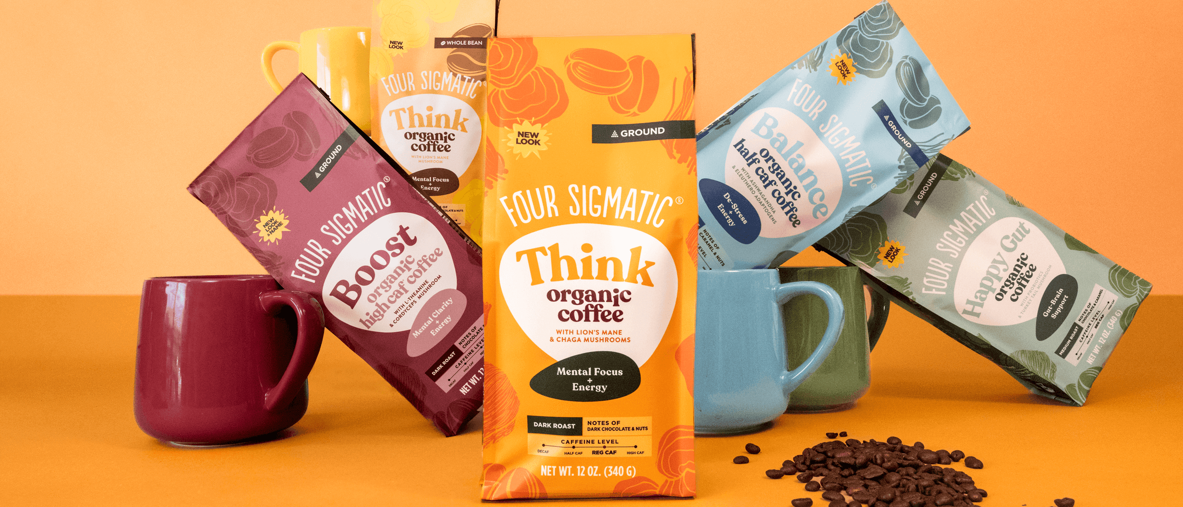 Four Sigmatic coffee bags with colorful designs and mugs on an orange background, promoting organic coffee for energy and focus.