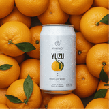 Yuzu Sparkling Water can surrounded by fresh Yuzu fruits, highlighting Kimino's citrus-infused unsweetened beverage.