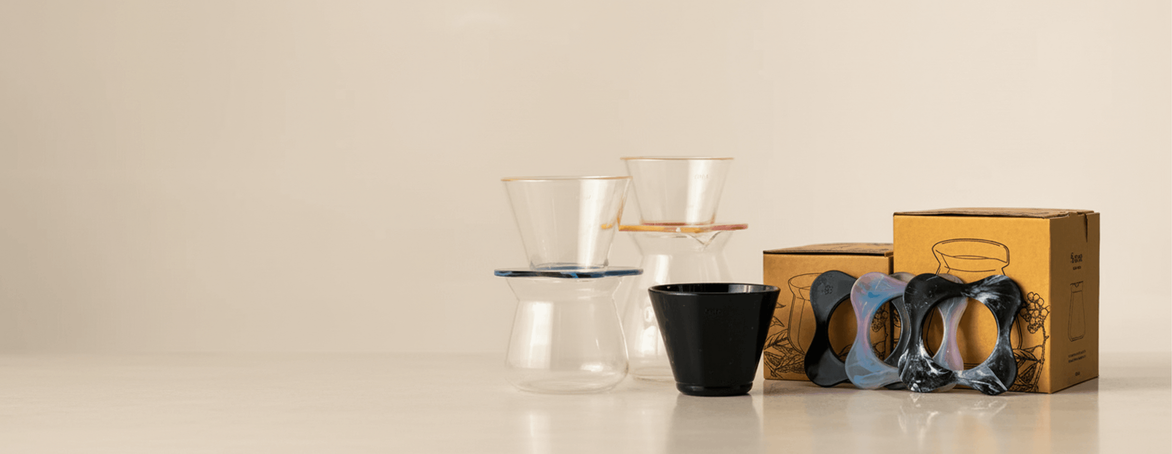 Stylish glass coffee drippers with colorful silicone bands and eco-friendly packaging, perfect for brewing artisanal coffee.