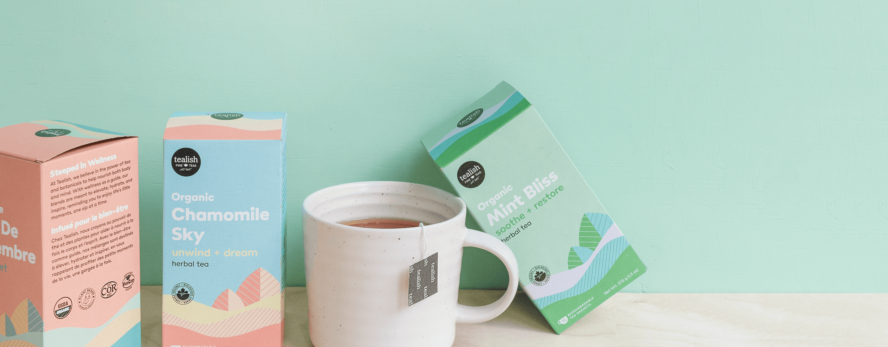 Organic chamomile and mint bliss tea boxes with a white mug on a mint green background