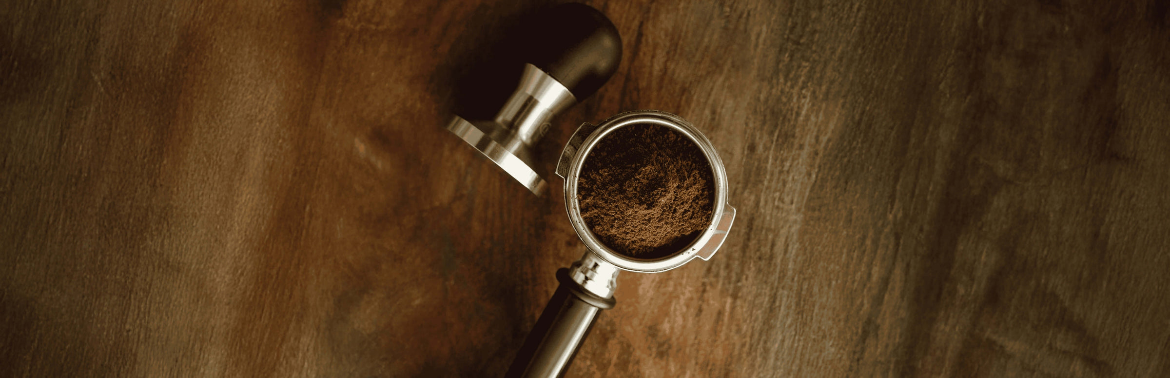 Freshly ground coffee in a portafilter on a wooden table, perfect for coffee lovers in Dubai, UAE.