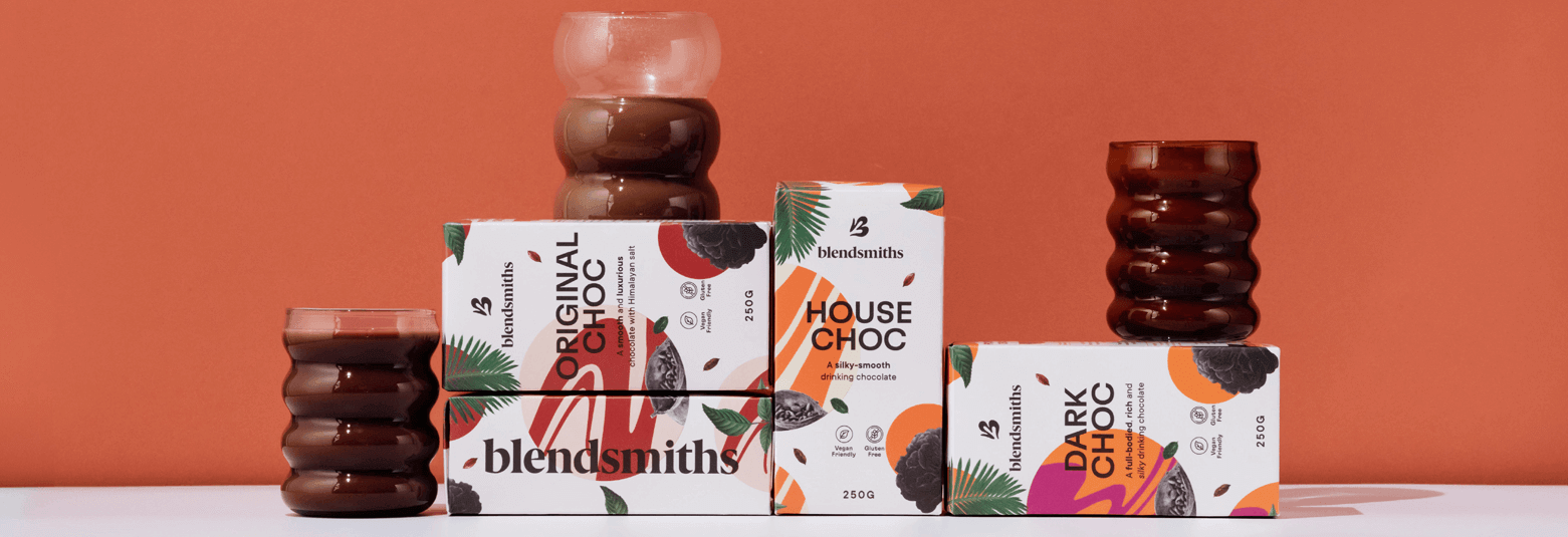 Blendsmiths artisan drinking chocolate collection, featuring Original Choc, House Choc, and Dark Choc blends. Premium, dairy-free, and ethically sourced hot chocolate drinks displayed with elegant glassware against a warm-toned background.