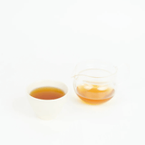 Chamomile Hojicha in a white cup and glass pitcher showcasing its warm, inviting color.