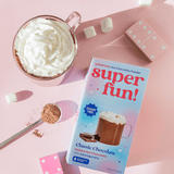 A cup of whipped hot chocolate with Superfun packaging featuring Classic Chocolate, SUGAR-FREE with ashwagandha.