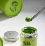 Era Dark Bamboo Chashaku — Matcha Spoon measuring matcha powder from an eco-friendly canister.