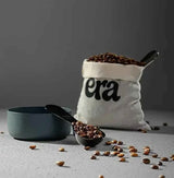 Ethiopia Guji Hambela Heirloom coffee beans in a measuring spoon and bag, showcasing specialty coffee quality.