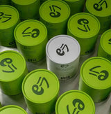 Hojicha - Uji, Kyoto tea cans featuring vibrant green branding and a standout white can.