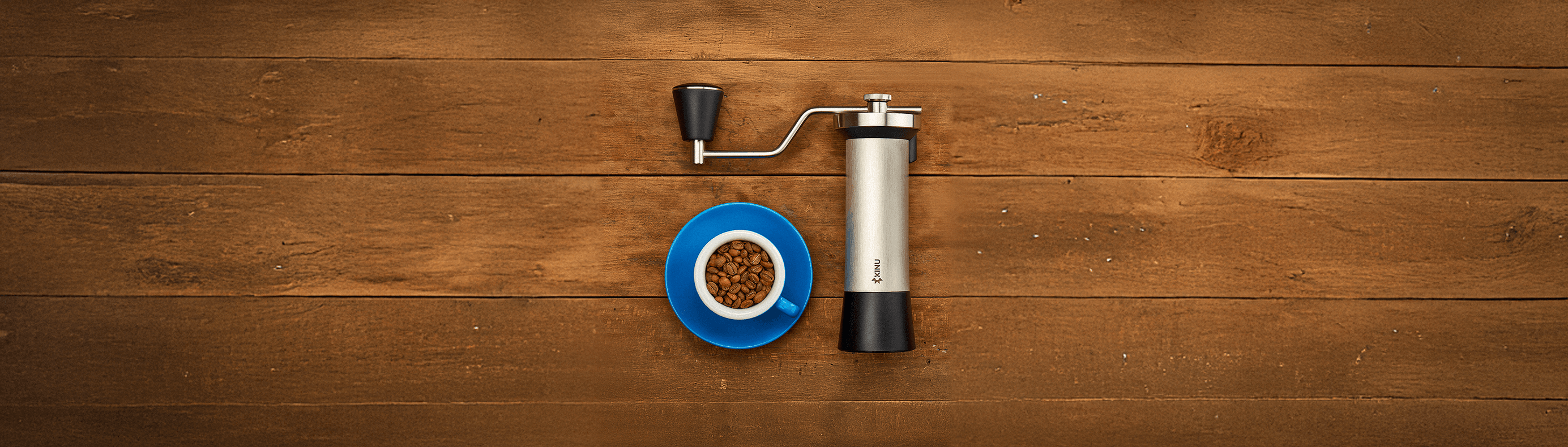 Coffee grinder next to a blue cup of coffee beans, perfect for coffee lovers and drinkware in Dubai, UAE.