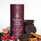 Mother’s Hug cacao brew packaging with a warm maroon design, featuring celestial gold details and spiritual hand illustrations.