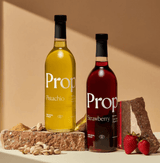 Two bottles of Proper Natural Syrups: Pistachio Syrup and Strawberry, gluten-free and vegan options.