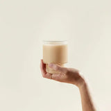 Lion's Mane Mushroom Powder in a creamy beverage held in hand, showcasing a natural brain-support supplement
