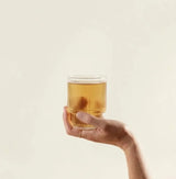 Cordyceps Mushroom Powder energy drink in glass held by hand, natural boost for gym lovers and afternoon energy