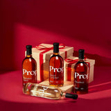 Bottles of Proper Natural Syrups including Pumpkin Spice Syrup, Salted Caramel, and Hazelnut with gift boxes.