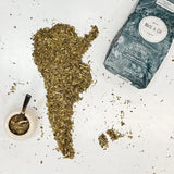 Pure Leaf Organic Yerba Mate loose leaves shaped like South America with packaging in the background.