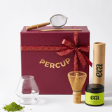 Tea-making set with 'PERCUP' box, glass, whisk, and 'era' container on a white background
