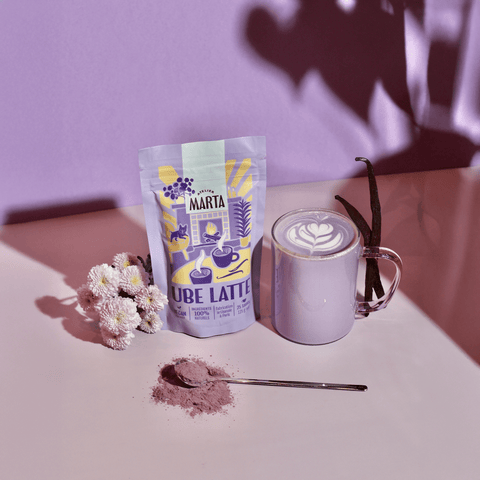 Ube Latte from Atelier Marta with purple packaging, a cup of latte, flowers, and spoon of powder.