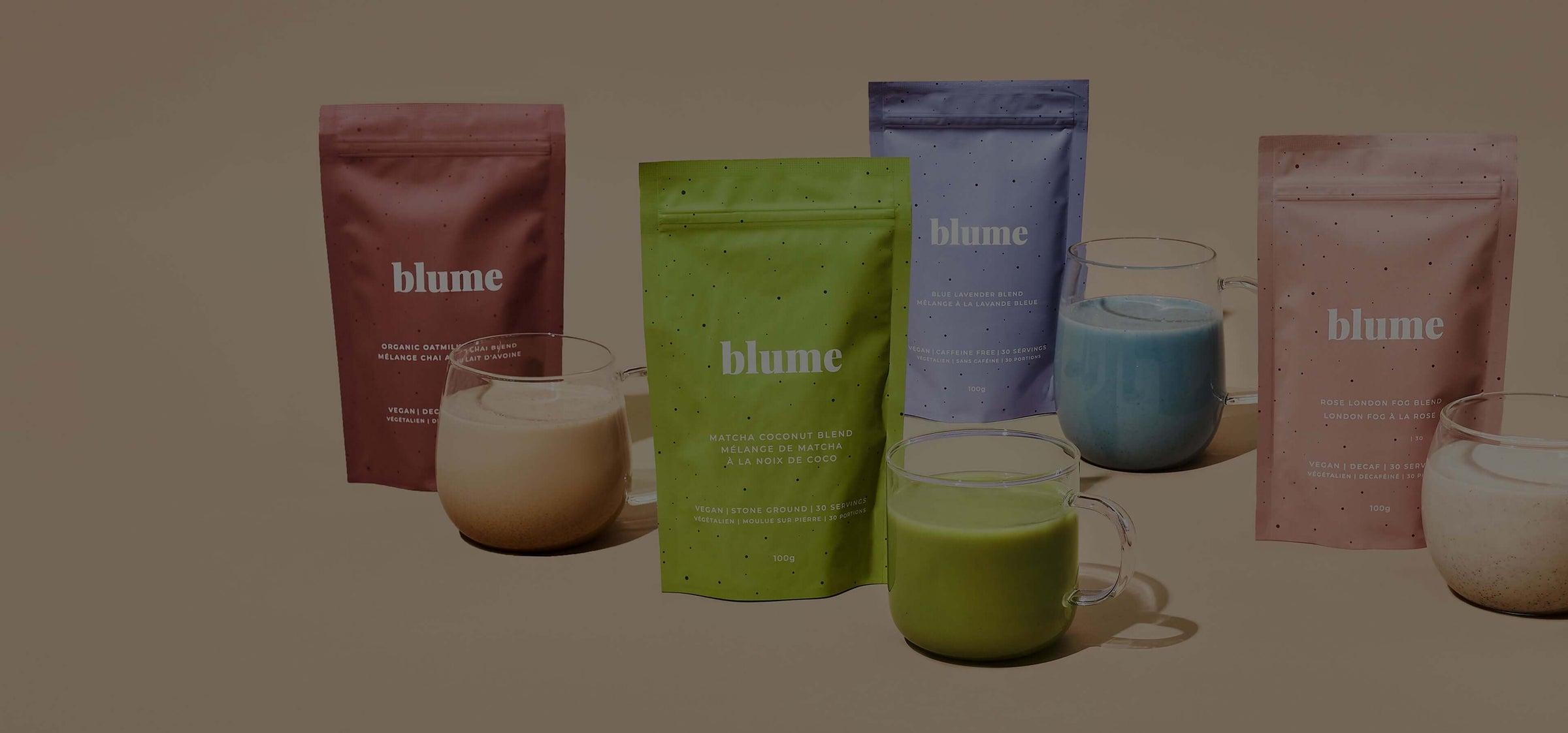Colorful Blume drink mix packets displayed with prepared beverages in glass mugs on a neutral background