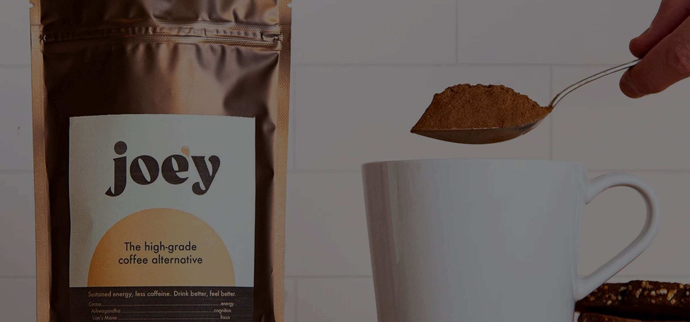 Joey high-grade coffee alternative being spooned into a white mug beside its packaged pouch