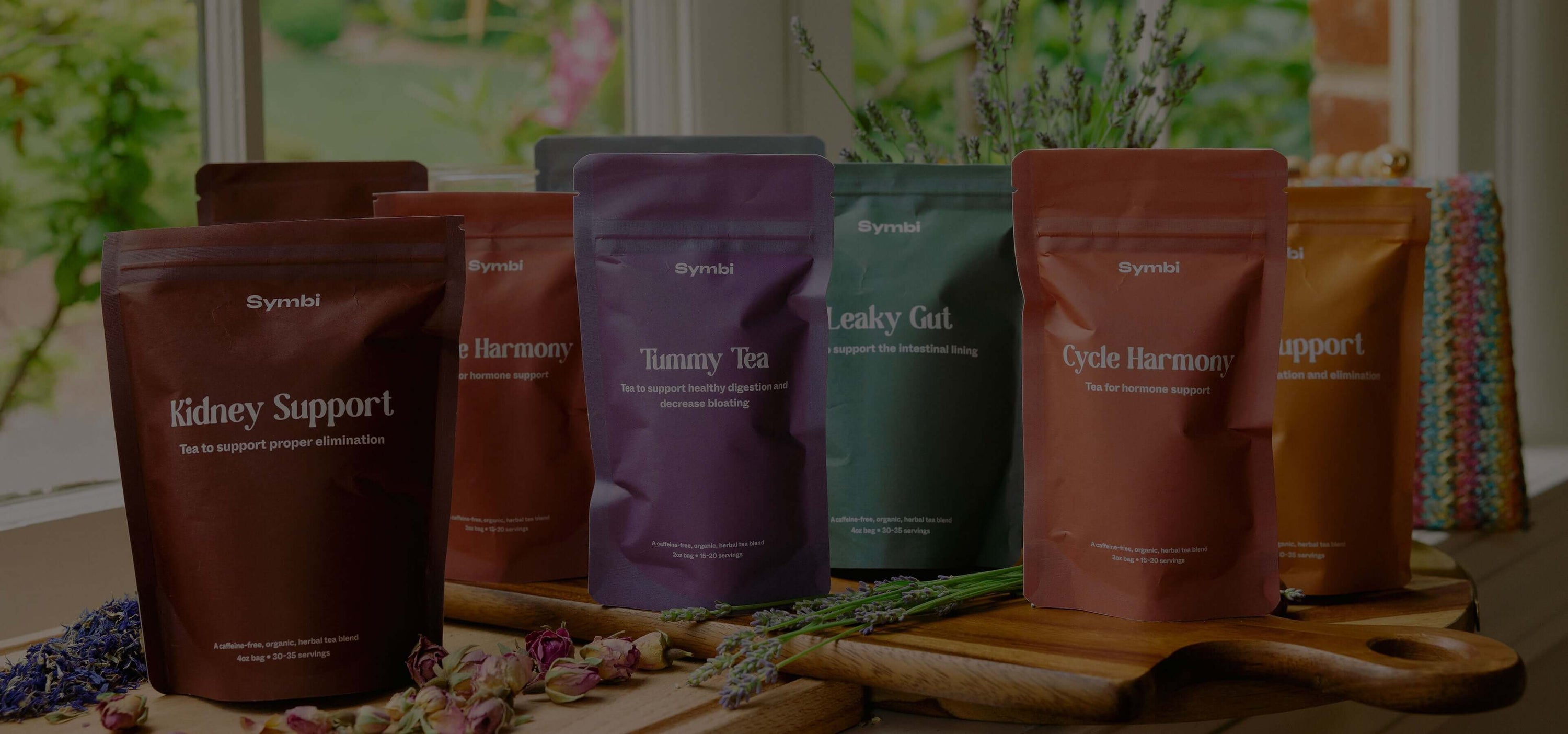 Symbiome supplement pouches for Kidney Support, Harmony, Turmeric Tea, Leaky Gut, Cycle Harmony and Support on a wooden table