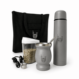Tuma tea-making kit with tote bag, thermos, glass jar, and accessories on a gray background